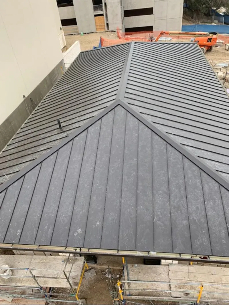 Commercial metal roof construction with crane equipment in New Orleans